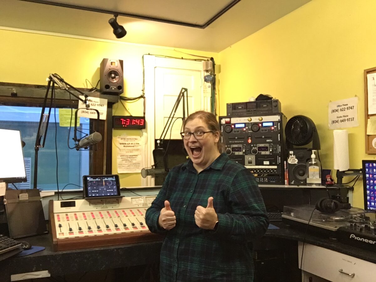 me giving two thumbs up and a cheesey grin, standing in front of the board, CD players, and mics in WRIR studio A